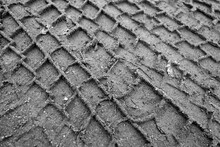 Tyre Tracks On Sandy Dirty Road In Black And White.