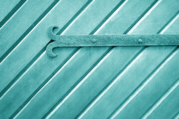 Wall Mural - Old metal door hinge on wooden door in cyan tone.