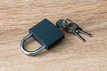 iron padlock with keys in the keyhole on a wooden surface concept prohibition security restriction