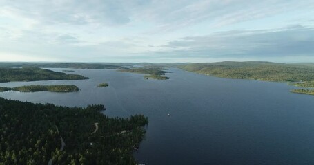 Wall Mural - Aerial view of the lake Inarijarvi in Lapland. Islands and forest at summer evening. Beautiful sunset with blue sky. Tourism and nature concept.	