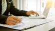 © ArLawKa - Business analysts create graphs of investment costs, real estate and other tax systems on their desks with laptops.