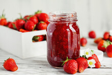 Homemade Strawberry Preserves Or Jam In A Mason Jar Surrounded By Fresh Organic Strawberries. Selective Focus With Blurred Foreground And Background.