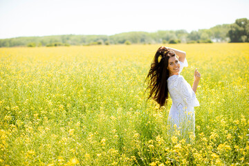 Wall Mural - Young woman in the rapeseed field