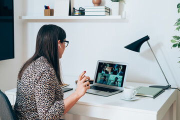 Wall Mural - Businesswoman Talking on Video Call Meeting with Colleagues During the Coronavirus Shutdown.
Business woman discuss with clients or coworkers at  web conference using a laptop and bluetooth earphones.