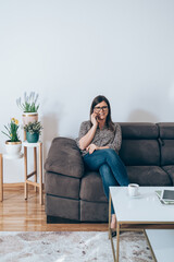 Wall Mural - Smiling Business Woman Sitting on Sofa and Talking on Mobile Phone.
Happy businesswoman relaxing on couch in living room at home and calling somebody on smartphone.