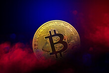 Golden Bitcoin Coin Is In Red And Blue Smoke Background. Cryptocurrency Concept
