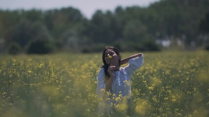 Wall Mural - Pretty young woman in the rapeseed field