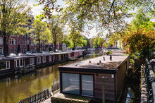 An Amsterdam Canal Full Of Houseboats In The Sunlight