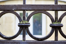 Detail Of An Old Wrought Iron Fence With A Round Pattern Covered With Moss.