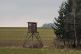 Fototapeta Krajobraz - Wooden lookout tower for hunting in the woods and on meadow