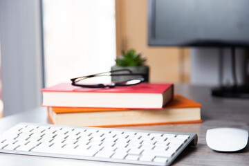 Sticker - Computer desk with books, glasses, keyboard, and mouse on it