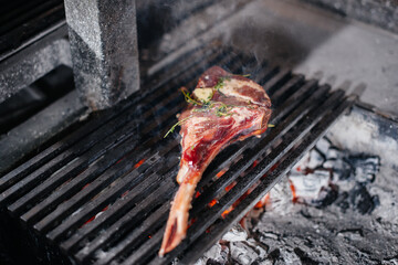 Juicy steak is grilled in a restaurant. Roasting meat in the fire on the grill.