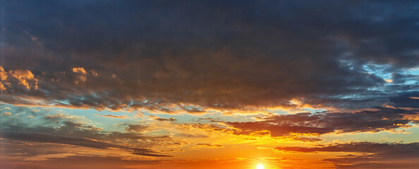 Wall Mural - setting sun painted impending dark rain clouds a golden orange color. impressive sunset before the s