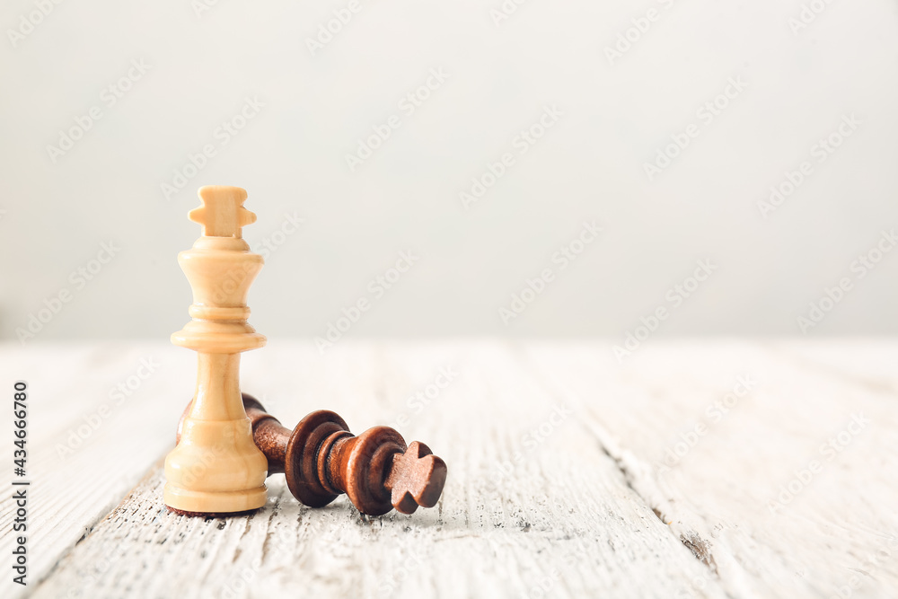 Chess pieces on white wooden background