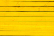 Surface Of Wooden Boards Painted With Yellow Paint. Yellow Wood Wall Background.