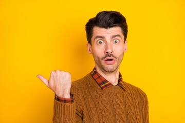 Poster - Photo of shocked amazed young man point thumb empty space sale news isolated on yellow color background