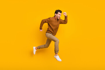 Sticker - Full size profile photo of optimistic nice brunet man run wear sweater isolated on yellow background