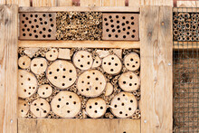 Detail Of An Insect Hotel Made Of Natural Materials Like Wood With Holes, Branches, Bamboo Sticks And Straws For A Better Biodiversity