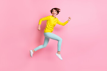 Sticker - Full length body size photo of woman jumping high running fast looking back isolated on pastel pink color background