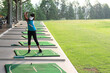 © sittinan - Women player golf swing shot on course or Girl golf player with driver shoot over lake, view from behind.