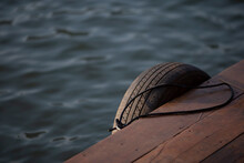 Old Car Tires Used At The Pier To Make The Boat Dock Soft, Prevent Shock. Photo For Background Selective Focus