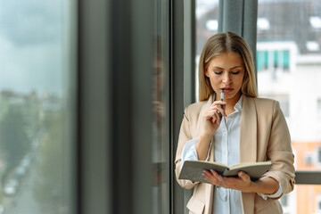 Business woman, holding notebook, devises new plans.