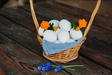 White Eggs In A Basket On A Wooden Background Blue Muscari Flowers