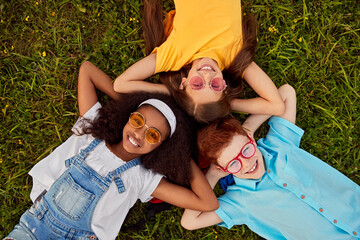 Company of diverse happy friends lying on grass