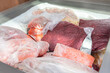Frozen food in the freezer. Bagged frozen meat and other foods in a horizontal freezer. Food preservation in low temperatures.