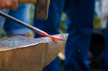 Wall Mural - blacksmith performs the forging of hot glowing metal on the anvil