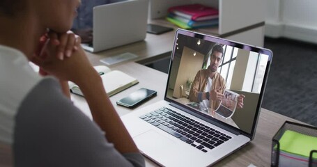 Poster - African american woman having a video conference on laptop with male office colleague at office