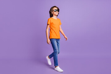 Sticker - Full length body size photo walking small boy wearing casual clothes sunglass smiling isolated pastel purple color background