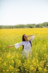 Wall Mural - Young woman in the rapeseed field