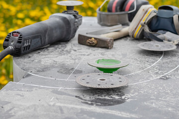 Wall Mural - Street lighting. a masked worker processes a granite stone with a special tool. Close-up.