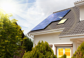 Modern house with solar panels.  Clear sky, sun.	