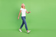 © deagreez - Full length body size photo senior woman walking on meeting laughing isolated on pastel green color background copyspace