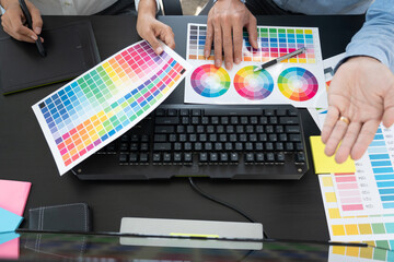 Poster - graphic designer team working on web design using color swatches editing artwork using tablet and a 
