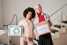Woman And Albino Man Holding Boxes With Second-rate Clothing For The Recycling