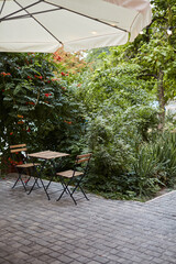 table and chairs on the terrace empty street cafe with garden