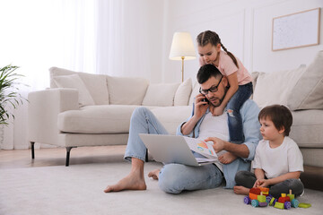 Overwhelmed man combining parenting and work at home