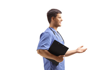 Poster - Male nurse in a blue uniform holding a clipboard and gesturing with hand