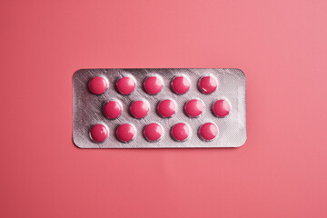 Blister pink pills close up isolated on pink background with copy space. Digestive medicine