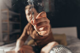 Fototapeta  - Man offering a hand rolled cannabis cigarette while sitting at the bed