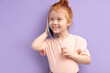 © alfa27 - Kid girl communicates on mobile phone, smiles and talks isolated on purple background. Closeup smiling kid talking on smartphone. People sincere emotions lifestyle concept