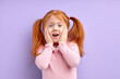 © alfa27 - surprised girl with natural red hair and freckles, stands over purple background touching cheeks, with wide opened mouth, look at camera in shock