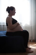 © Kekyalyaynen - Calm pregnant woman sitting in bed at home bedroom and enjoyng the pregnancy