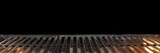 Fototapeta Desenie - Barbecue Fire Grill Isolated On Black Background. BBQ Flaming Charcoal Grill Isolated. Hot Barbeque Charcoal Cast Iron Grill With Bright Flames Of Fire. Abstract Panoramic Grill Wide Banner.