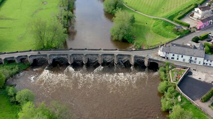 Wall Mural - Aerial view of a fast flowing river and small, rural Welsh town