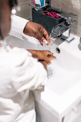 Wall Mural - Close up image of mother helping her daughters to wash her hands