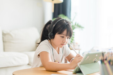 Asian girl student online learning at home.study online video call zoom teacher, kid girl learn english language online with tablet.